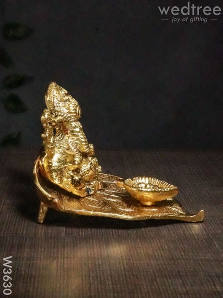 White Metal Ganesha In Pipal Leaf With Diya Gold Finish - W3630 Diyas
