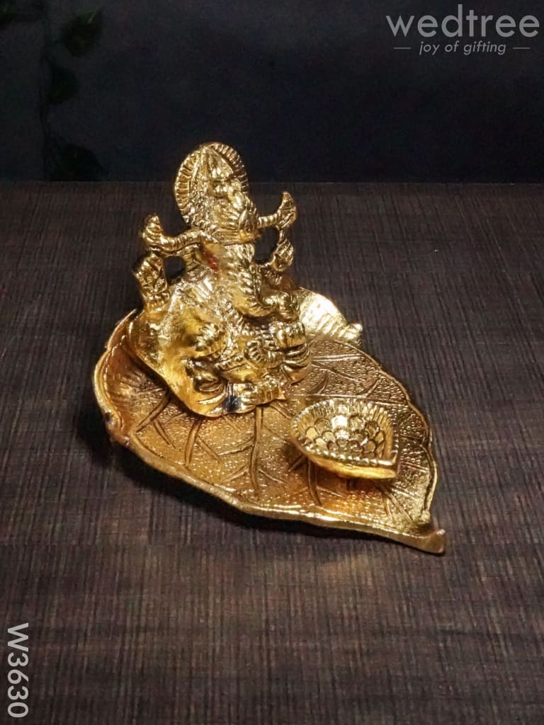 White Metal Ganesha In Pipal Leaf With Diya Gold Finish - W3630 Diyas