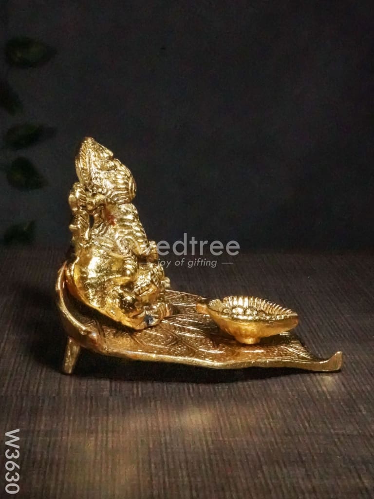 White Metal Ganesha In Pipal Leaf With Diya Gold Finish - W3630 Diyas